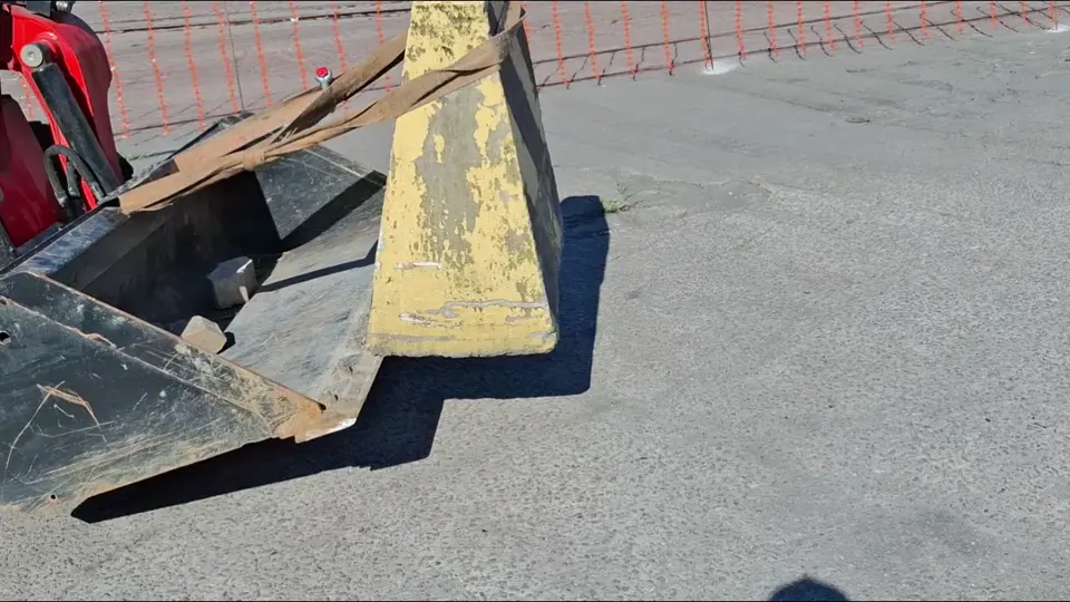 Vídeo da minicarregadeira Manitou 1650R transportando prisma de concreto em área portuária
